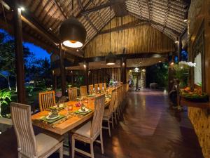 a long dining room with a long table and chairs at Taman Ahimsa by Elite Havens in Canggu