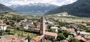 eine Luftansicht einer Stadt mit Bergen im Hintergrund in der Unterkunft Hotel Tyrol in Mals im Vinschgau