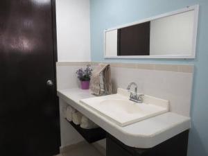 y baño con lavabo blanco y espejo. en 1 Céntrico y Acogedor Departamento para 2 a 4 personas, en Cancún