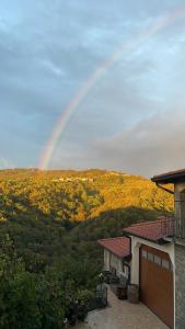 a rainbow in the sky above a house with at Zarova Apartment with wine tasting experience in Kojsko