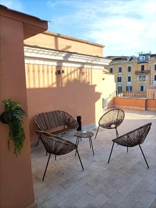 patio z 3 krzesłami i stołem w budynku w obiekcie Major House - Luxury Apartments w Rzymie
