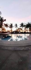 una gran piscina de agua con palmeras en el fondo en La Maison transient house, en Calapan