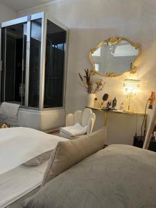- une chambre avec un lit et un miroir dans l'établissement FEMME noir LUXURy spa EXPERIENCE, à San Nicola La Strada