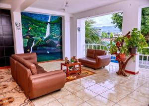 ein Wohnzimmer mit 2 Stühlen und einem Gemälde in der Unterkunft HOSPEDAJE LA MERCED in Juanjuí