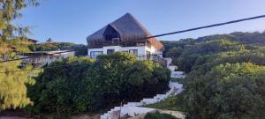 a house on a hill with stairs leading up to it at Seven Heaven do Indico in Inhambane