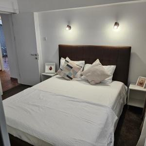 コンスタンツァにあるCliff Sunrise Apartmentの白いシーツと枕が備わったベッドのある寝室