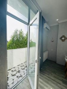 een glazen deur in een kamer met een balkon bij Kate's cozy apartment in Koetaisi