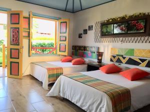 a hotel room with two beds and a window at Mamatina Hotel in Santa Rosa de Cabal