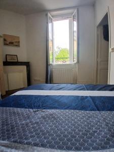 a bedroom with a blue bed with a window at Appart Rez de jardin in Dijon