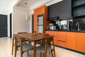 a kitchen with a wooden table and chairs in it at Mickey's Magic Urban Suites Jelutong Penang, Seaview in Jelutong