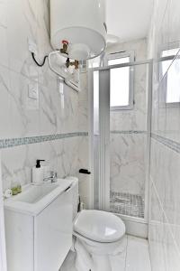 a white bathroom with a toilet and a shower at Appartement Rose Moderne Proche de la capitale in Gagny