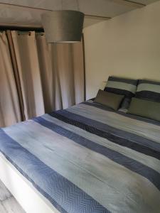 - une chambre dotée d'un lit avec des draps bleus et gris dans l'établissement Chalet dans propriété à Biscarrosse, à Biscarrosse