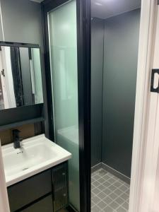 a bathroom with a sink and a glass shower at Houseboot solcamastraat 24 c in Suameer