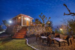 a group of chairs sitting in front of a building at Ransuli mountain retreat in Dehradun