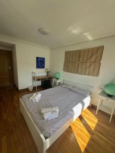 a bedroom with a bed with two towels on it at Habitaciones Hondar-Gain 10 in Zumaia