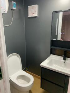 a bathroom with a white toilet and a sink at Houseboot in Suameer