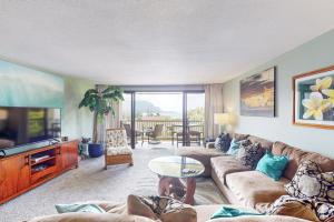 ein Wohnzimmer mit einem Sofa und einem TV in der Unterkunft Hanalei Bay Resort 6221 in Princeville