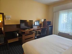 a hotel room with a bed and a desk with a television at Comfort Inn & Suites Ankeny - Des Moines in Ankeny