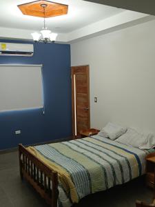 a bedroom with a bed with a blue wall at Confortable apartamento in Rivas