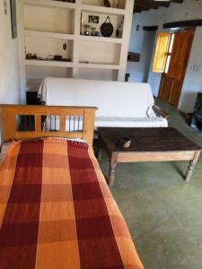 a bedroom with a bed and a bench and a table at El Paraiso in Tinogasta