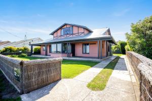 a house with a brick fence in front of it at Beachfront Bliss - Wi-fi Bbq Group House in Victor Harbor