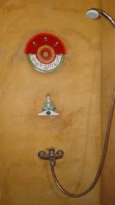 a shower with a hose attached to a wall at El Paraiso in Tinogasta