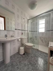 a bathroom with a toilet and a sink and a shower at Apartamento Maresía in Arrieta