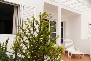 a white chair sitting on the porch of a house at Apartamento Maresía in Arrieta
