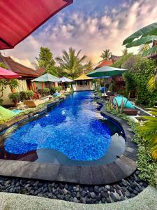 a swimming pool with blue water in a resort at Sunny Rose Bungalows Gili Air in Gili Islands