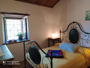 Schlafzimmer mit einem Bett mit einem schmiedeeisernen Kopfteil in der Unterkunft Il mulino che fu la filanda in Pennabilli