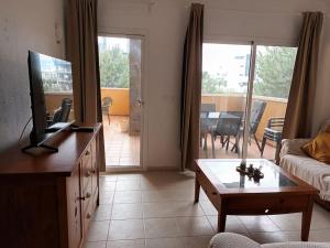 sala de estar con sofá, TV y mesa en Higuerón 4 Fuengirola Beach, en Fuengirola