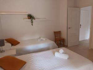 una habitación de hotel con 2 camas y una silla en Higuerón 4 Fuengirola Beach, en Fuengirola