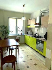 una cocina con armarios amarillos y una mesa con sillas en Автовокзал, en Rivne