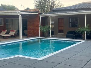 a swimming pool in front of a house at Horizon Bed and Breakfast in Roodepoort