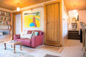 uma sala de estar com um sofá vermelho e uma mesa em Adelaide Hills Camellia Cottage Wifi em Crafers