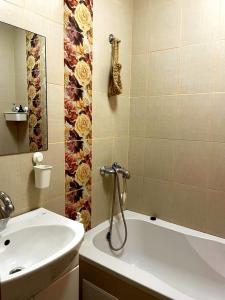 Un baño con bañera blanca y lavabo. en Автовокзал, en Rivne