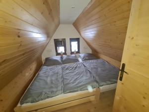 een bed in een houten hut met 2 ramen bij chataugryšánků in Šternberk