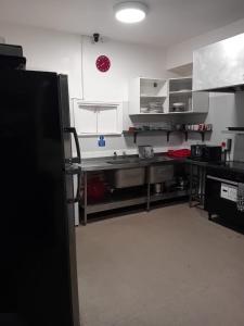 eine Küche mit Küchengeräten aus Edelstahl und einem schwarzen Kühlschrank in der Unterkunft Green Lodge-Room-09 in Liverpool