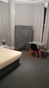 ein Schlafzimmer mit einem Bett, einem Tisch und einem Stuhl in der Unterkunft Green Lodge-Room-09 in Liverpool
