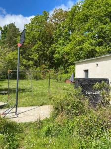 un panier de basket avec filet dans un champ dans l'établissement Tiny House DALIA Jardin & forêt 10 min de la gare, à Dammarie-les-Lys
