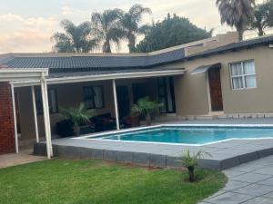 a house with a swimming pool in front of a house at Horizon Bed and Breakfast in Roodepoort