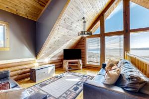 ein Wohnzimmer mit Sofa und Fernseher in der Unterkunft Cabin Overlooking The Harbor in Garden City