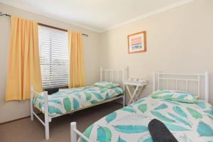 A bed or beds in a room at Goolwa Blue Escape - Beach Spacious Wi-fi