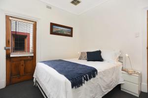ein Schlafzimmer mit einem Bett mit einer blauen Decke darauf in der Unterkunft City Apt no 7 at Cecil Mansions with 2Parking in Adelaide