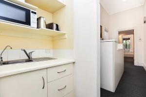 uma cozinha com um lavatório e um micro-ondas em Cecil Mansions Wi-fi Parking Central Location em Adelaide