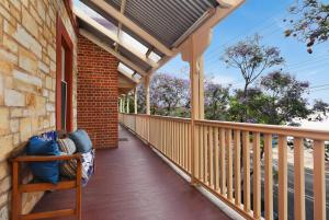 um alpendre de uma casa com um corrimão de madeira em Cecil Mansions Wi-fi Parking Central Location em Adelaide