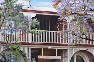 ein Gebäude mit einem Balkon mit lila blühenden Bäumen in der Unterkunft City Apt no 7 at Cecil Mansions with 2Parking in Adelaide + 9 Fotos