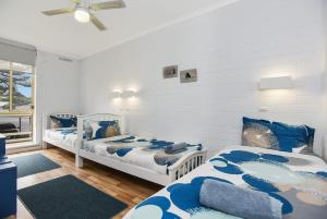 two beds in a room with blue and white at 'The Dolphins 7' - Beachfront View To Remember in Port Elliot