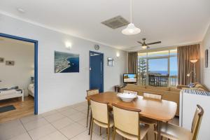 a dining room and living room with a table and a couch at 'The Dolphins 7' - Beachfront View To Remember in Port Elliot