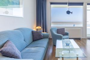 sala de estar con sofá azul y mesa en Haus Atlantic, FeWo 505 en Döse